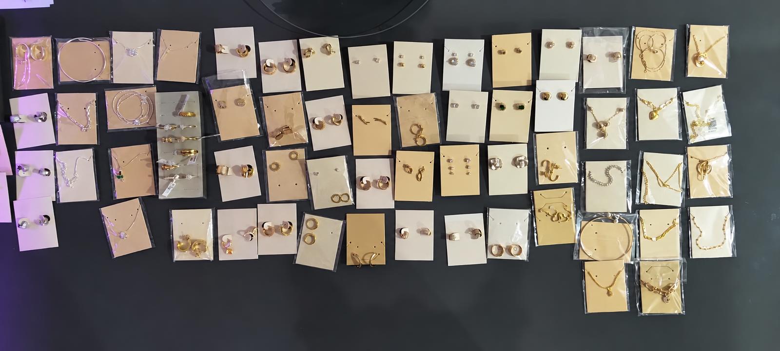 Coleção de semijoias banhadas a ouro e prata sobre mesa
